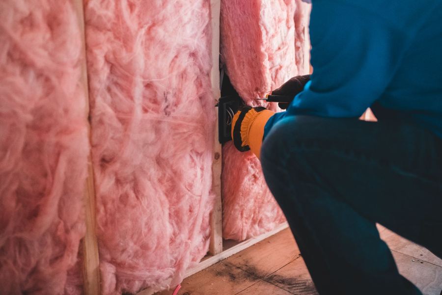 Lã mineral sendo instalada dentro de uma parede
